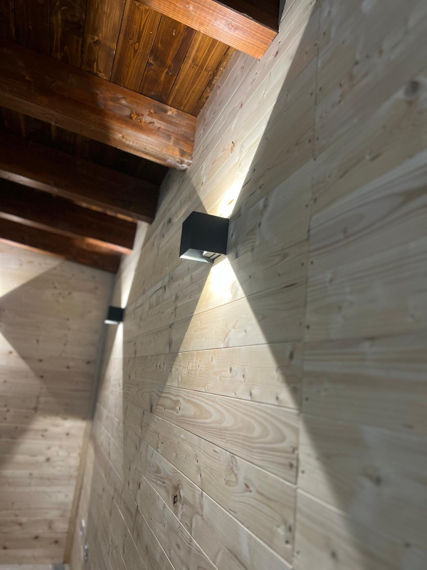 Scatola portafusibili elettrica con fili rossi e neri all'interno di un involucro bianco.