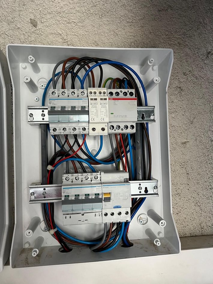 Pannelli solari installati su un tetto di tegole, con vista su un paesaggio suburbano sotto un cielo nuvoloso.