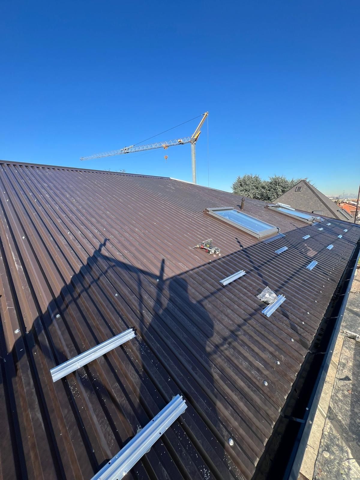 Tetto con pannelli solari e staffe di montaggio sotto un cielo azzurro e limpido.