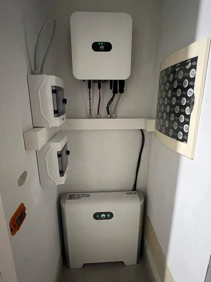 Scatola portafusibili elettrica con fili rossi e neri all'interno di un involucro bianco.