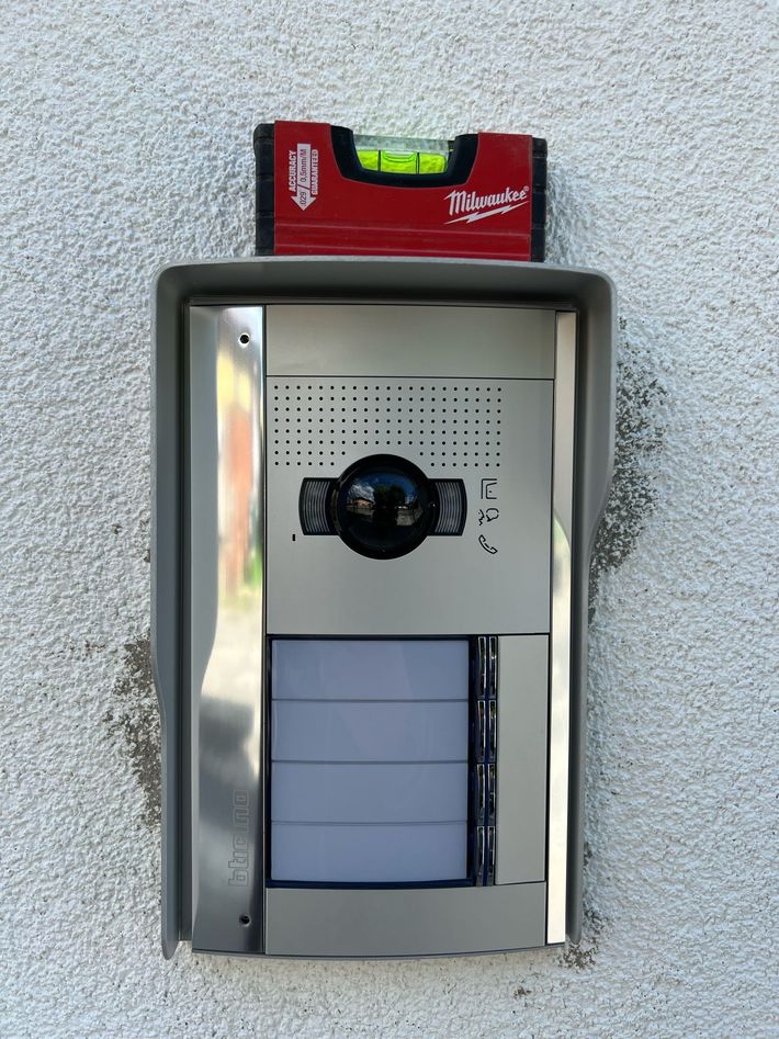 Pannelli solari installati su un tetto di tegole, con vista su un paesaggio suburbano sotto un cielo nuvoloso.