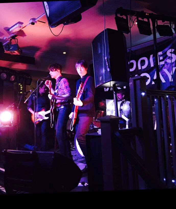 A band is playing in front of a sign that says odies day