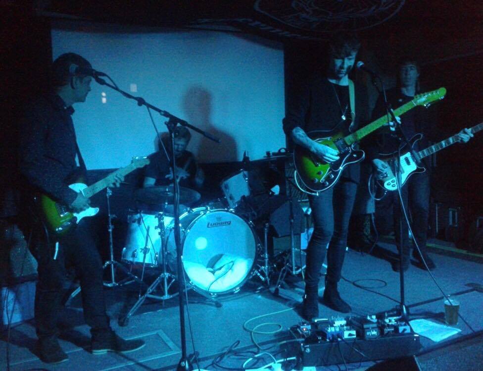 A group of people playing guitars and drums on a stage