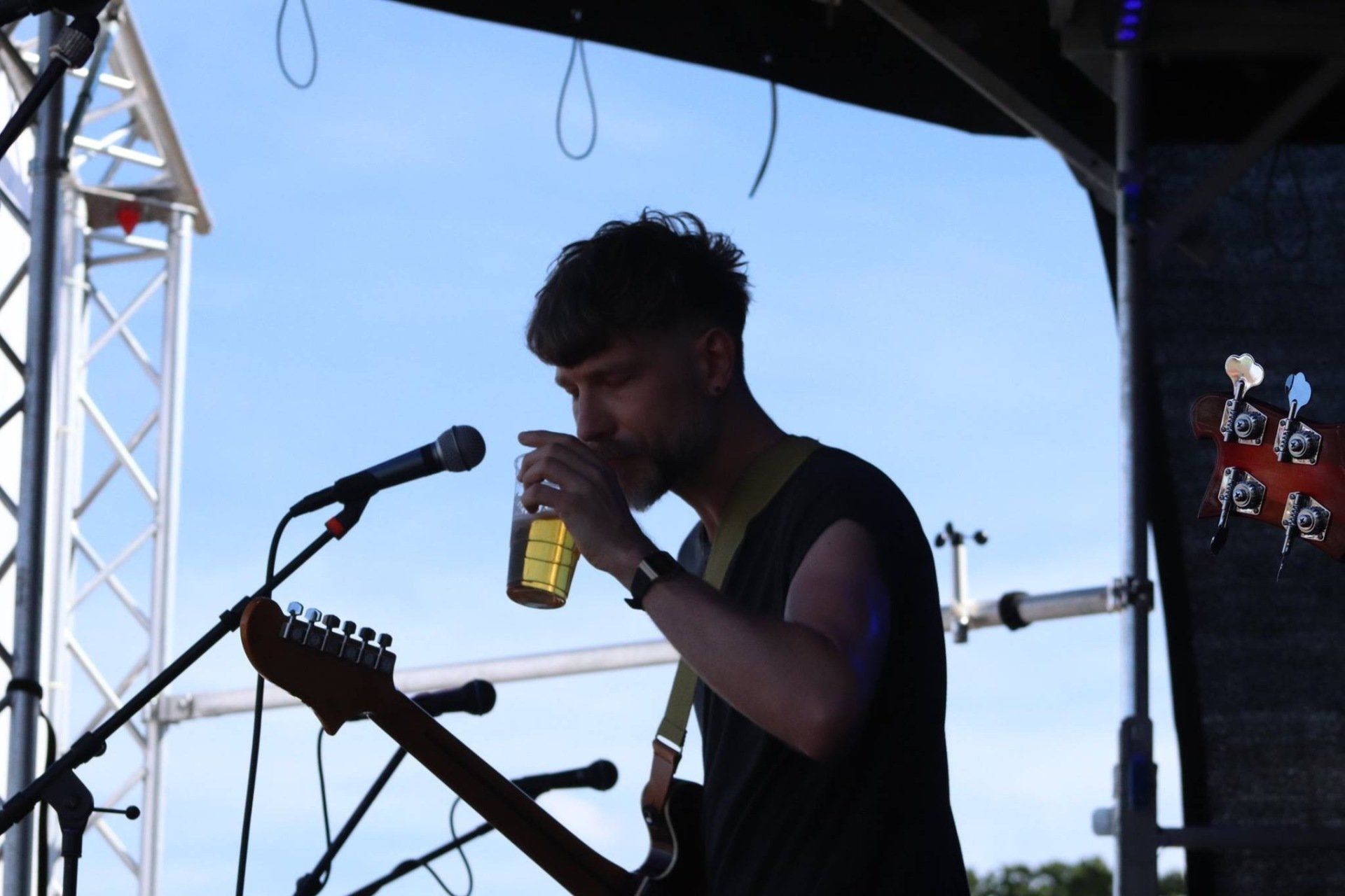 A man singing into a microphone while playing a guitar