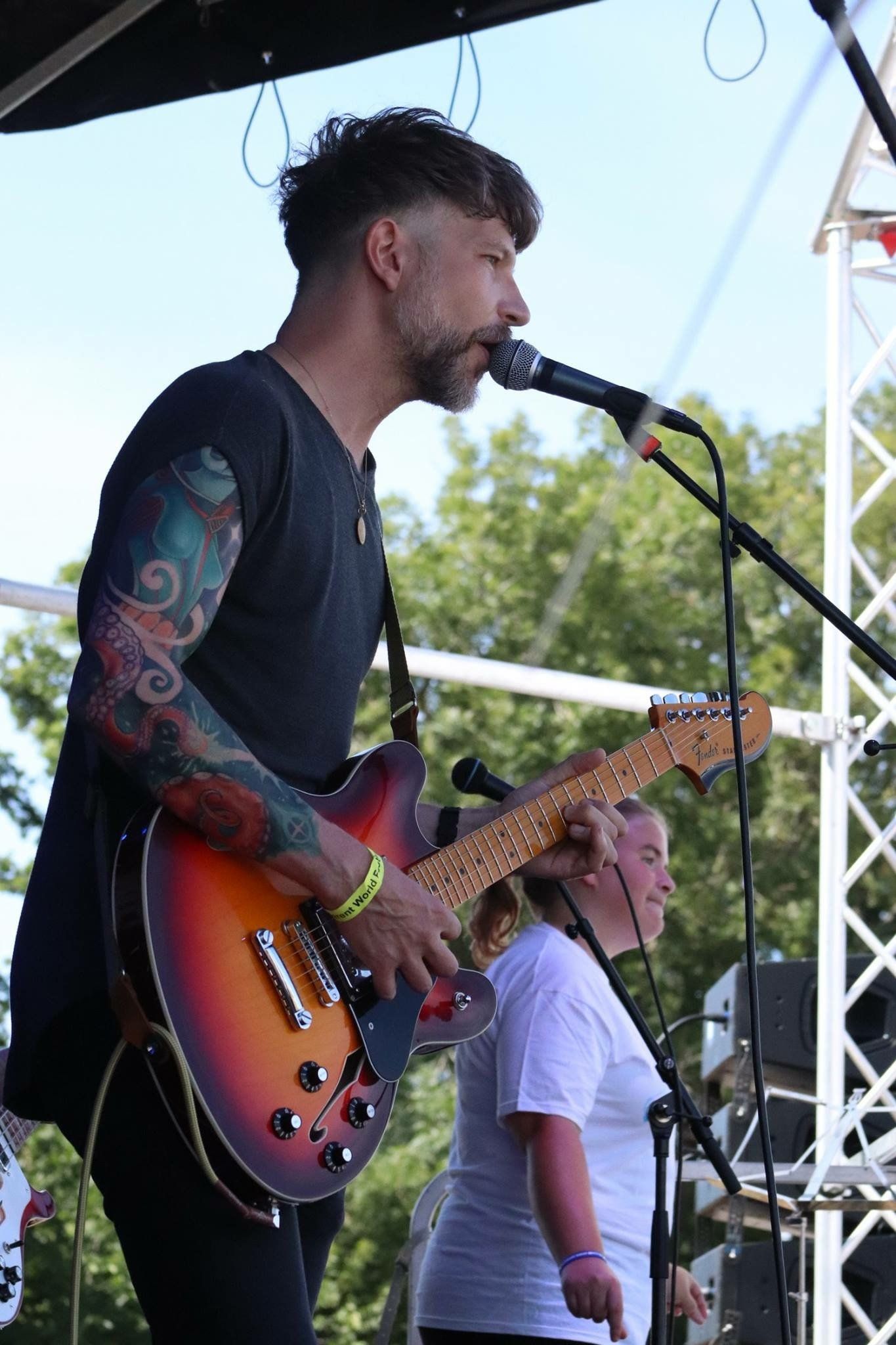 A man is singing into a microphone while playing a guitar.