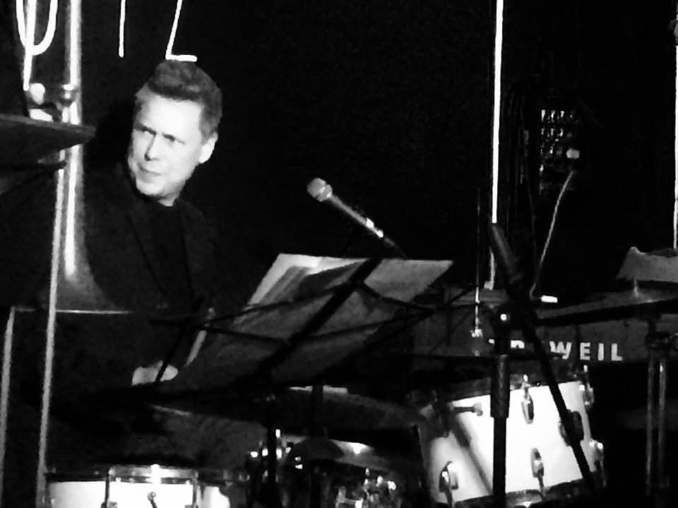 A man playing a trombone in front of a veil amp