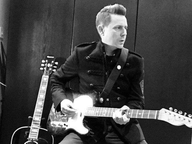 A black and white photo of a man playing a guitar