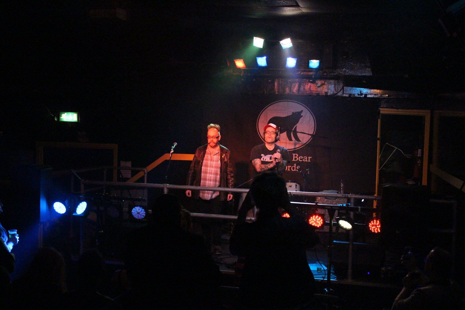 Two men are standing on a stage in front of a sign that says ' abercrombie & fitch '