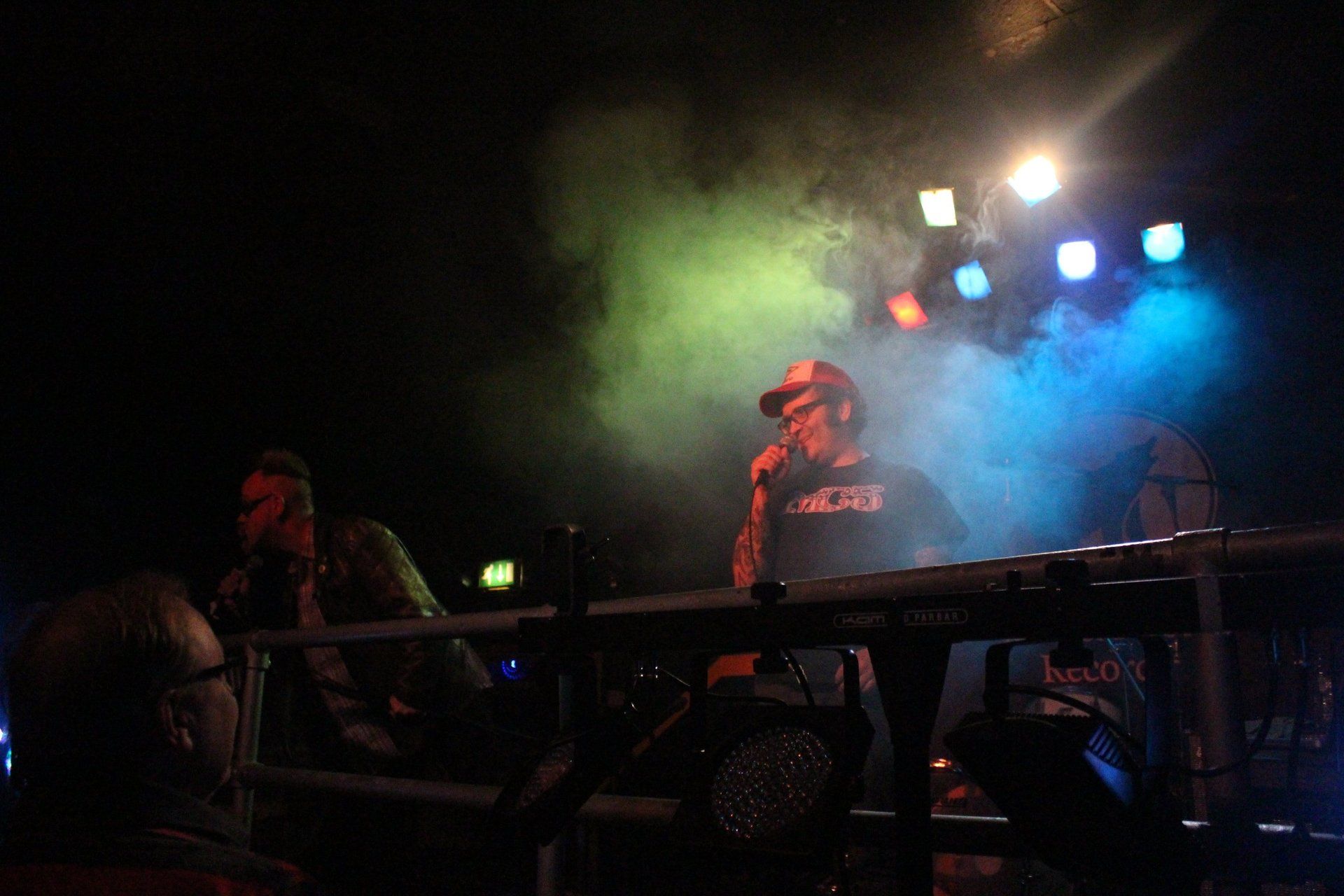 A man is singing into a microphone on a stage at a concert.