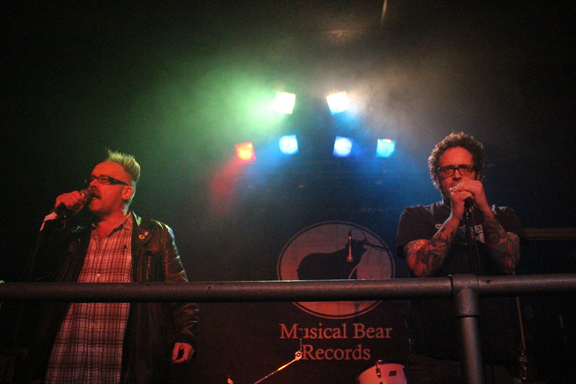 Two men singing in front of a sign that says musical bear records