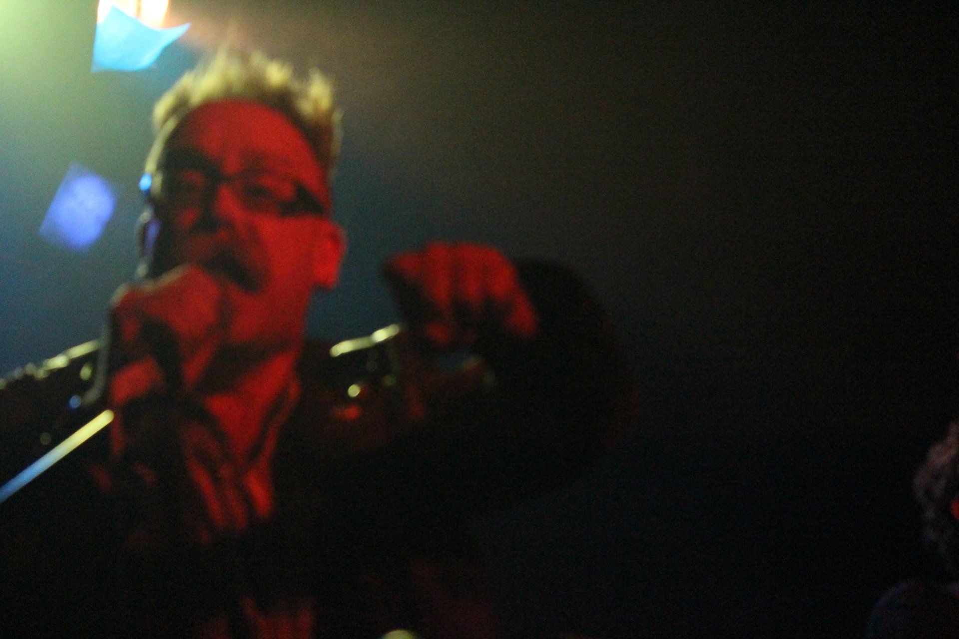 A man singing into a microphone in a dark room