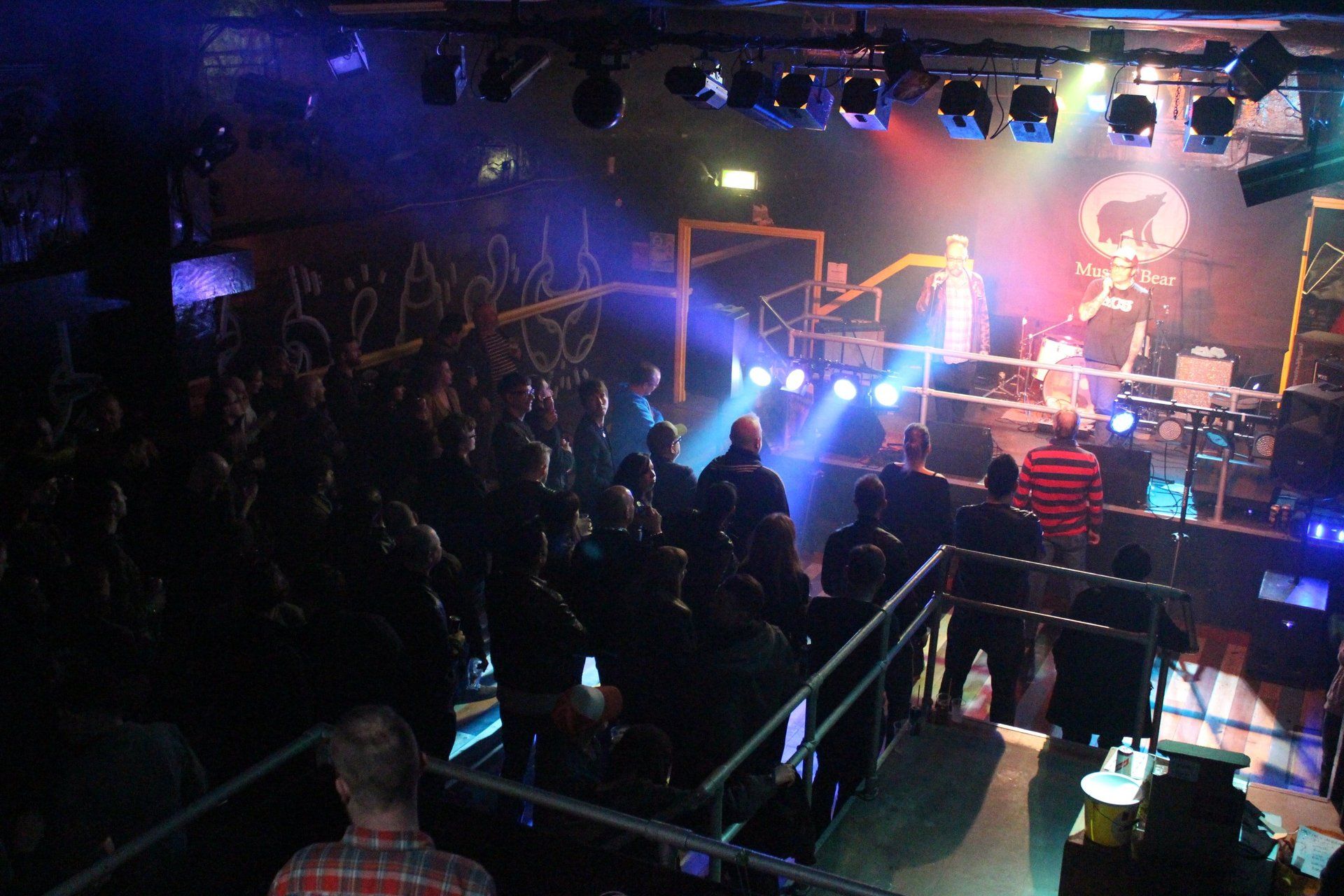 A crowd of people are watching a band perform on stage