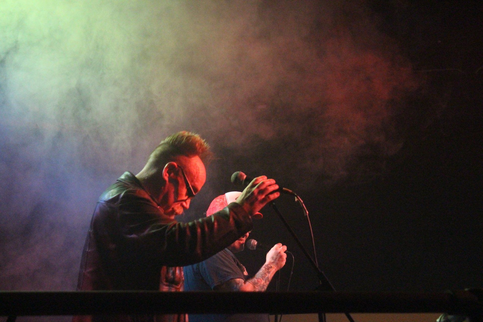 A man is singing into a microphone on a stage.