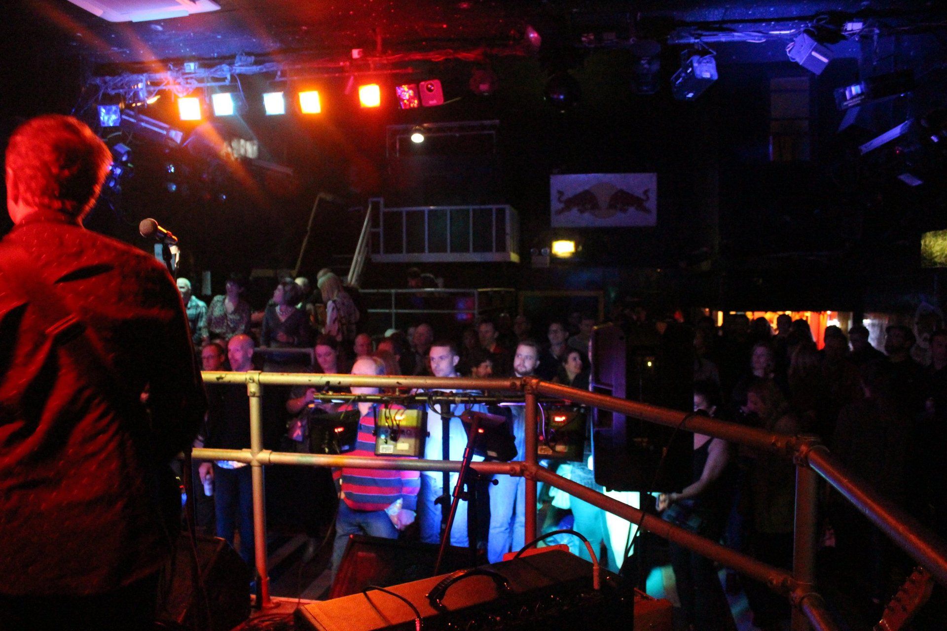 A man stands on a stage in front of a crowd at a red bull concert