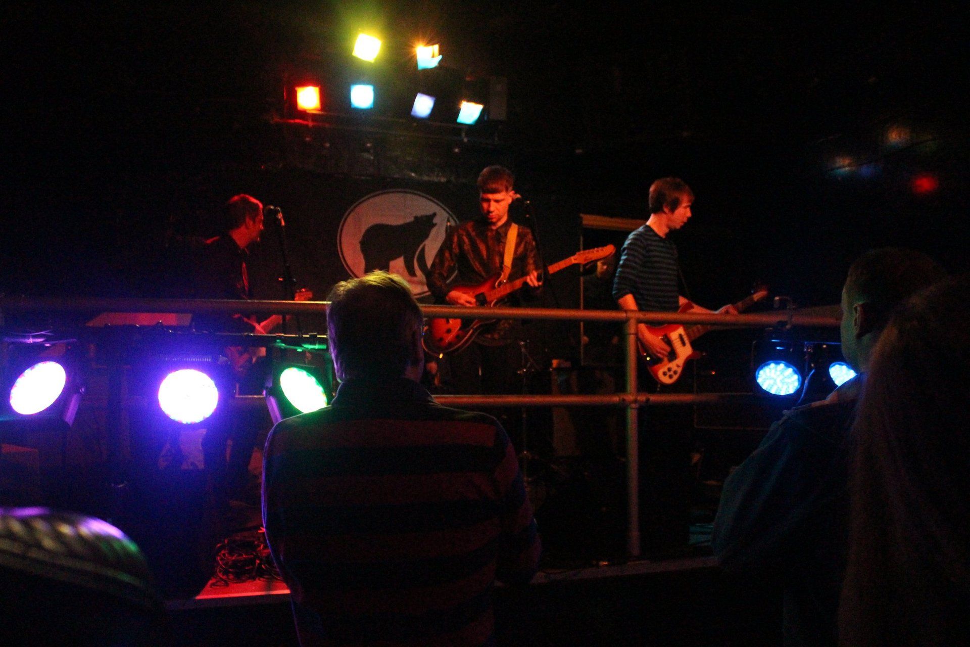 A group of people are watching a band perform on stage.