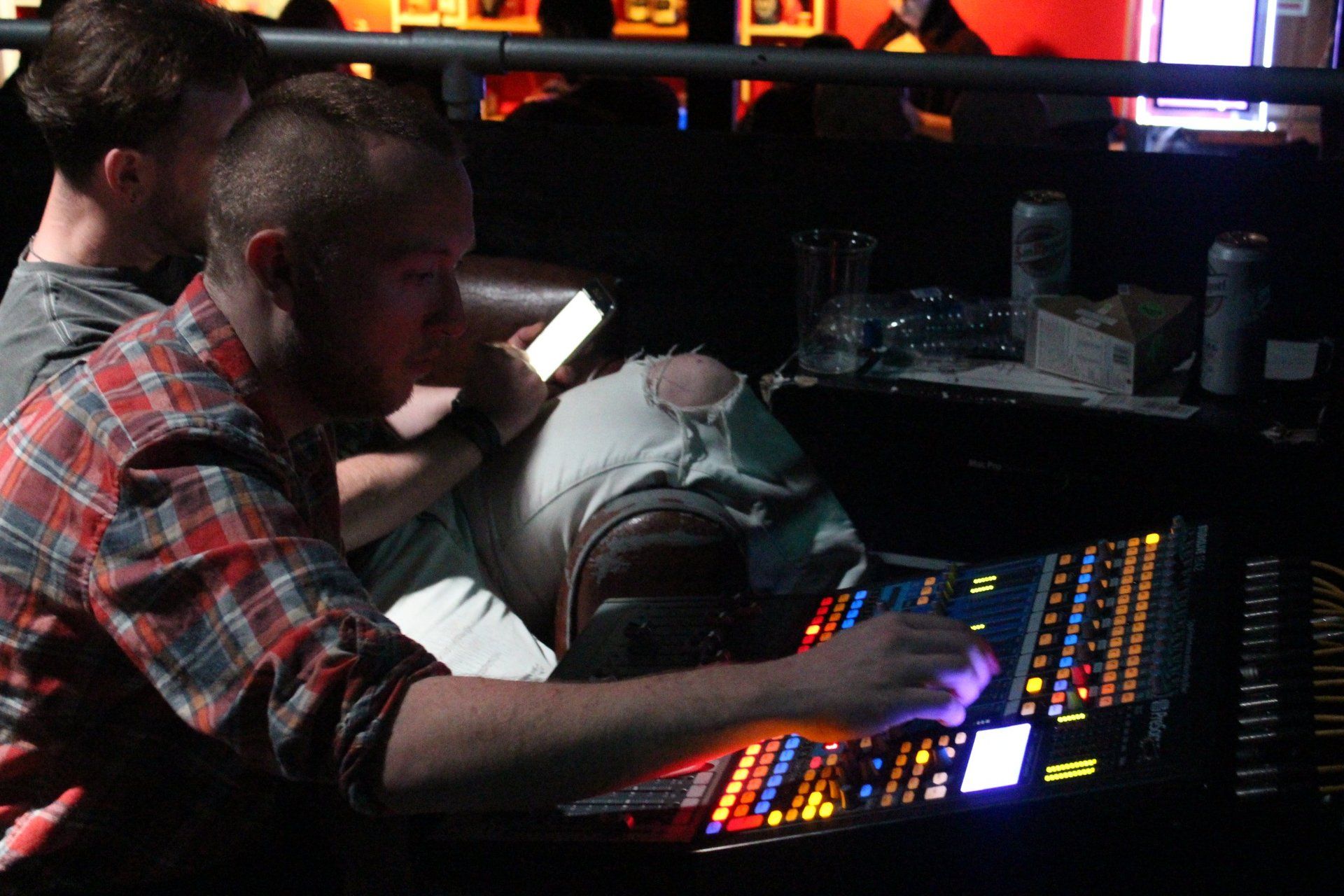 A man in a plaid shirt is typing on a keyboard