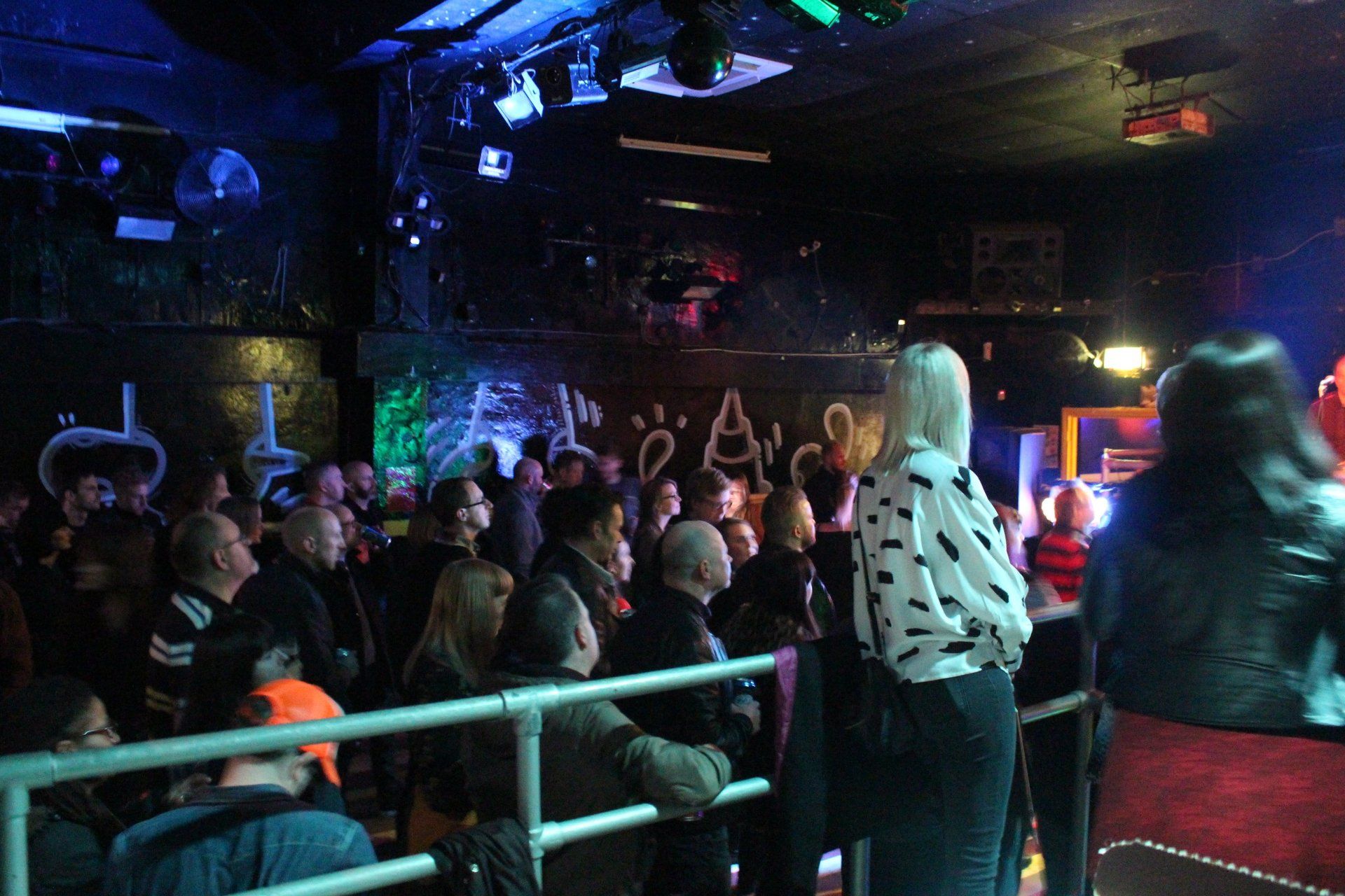 A crowd of people watching a concert in a dark room