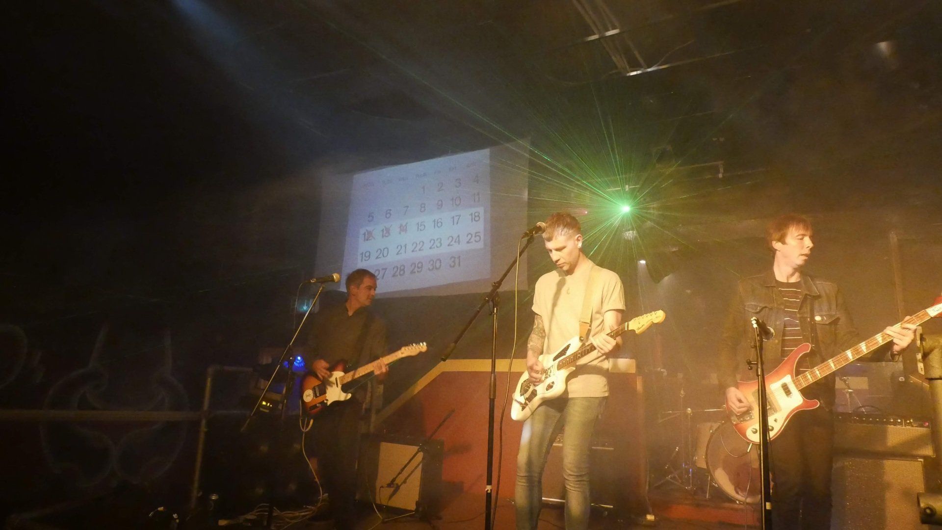 A group of men are playing guitars on a stage.