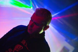 A man is standing in front of a stage with a lot of lights behind him.