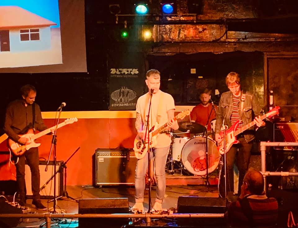 A man singing into a microphone while playing a guitar