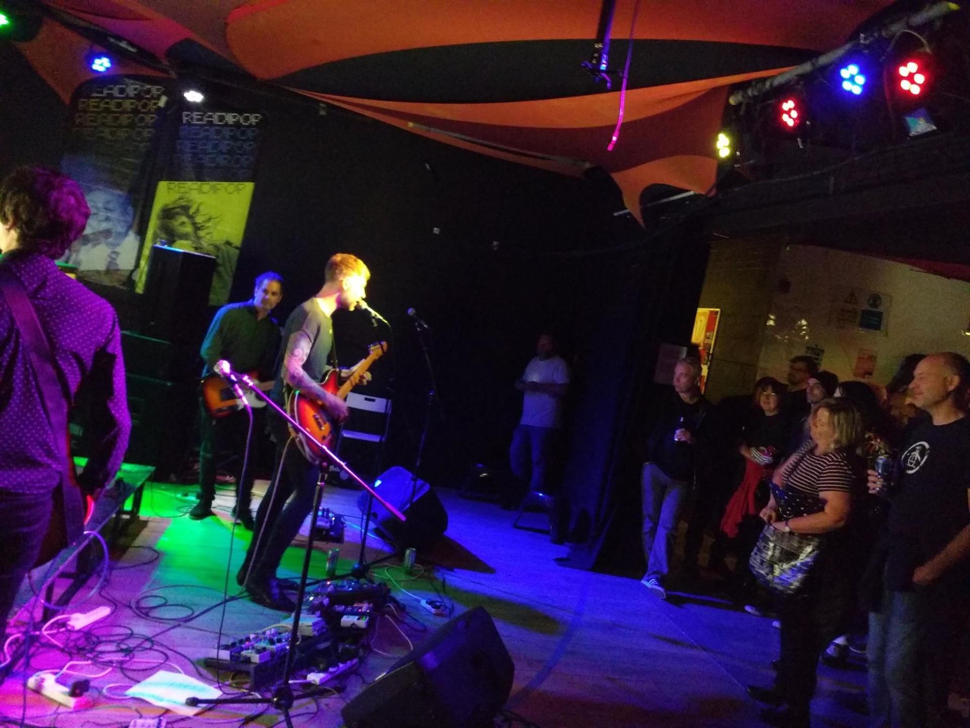 A group of people are watching a band perform on stage