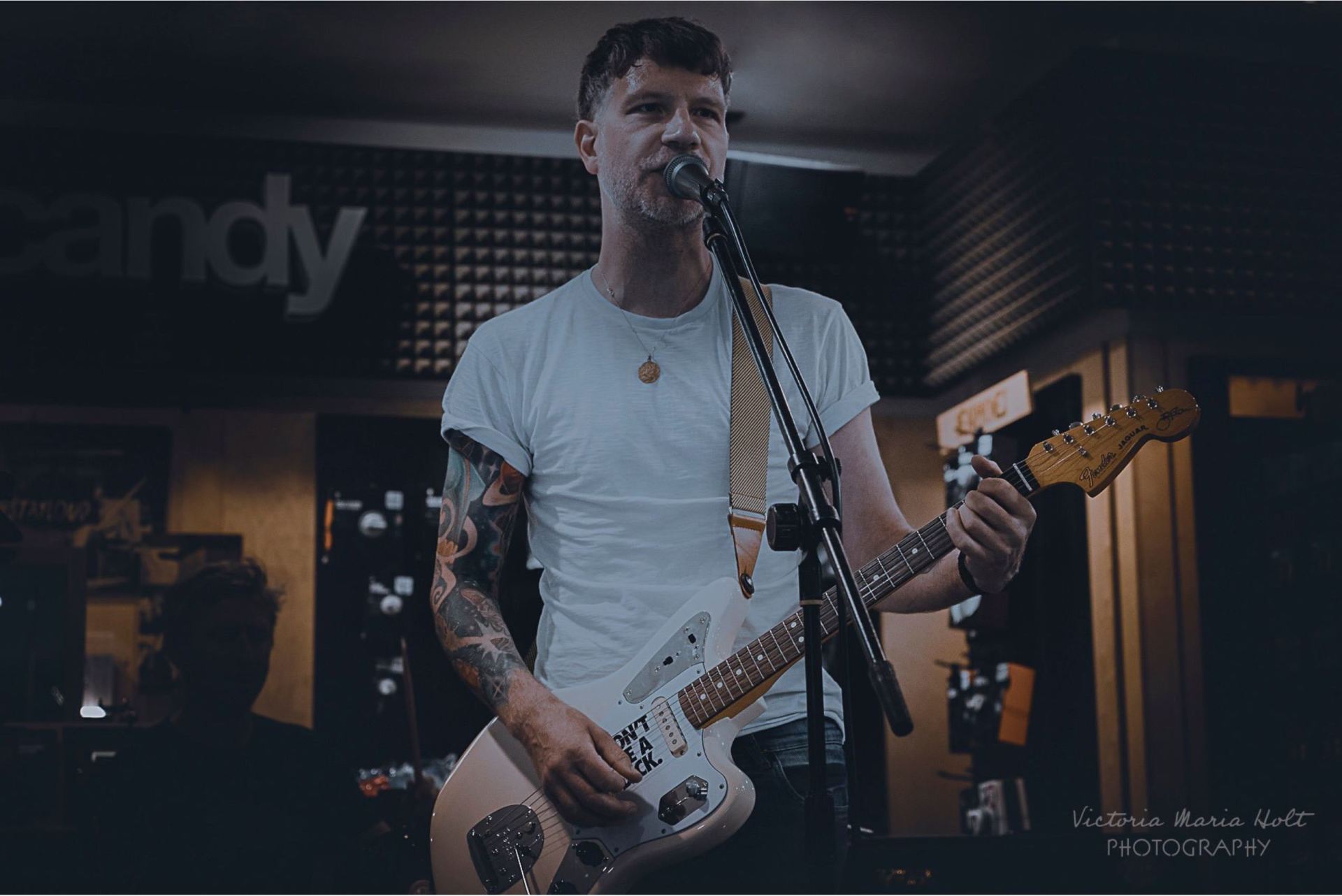 A man is playing a guitar and singing into a microphone.