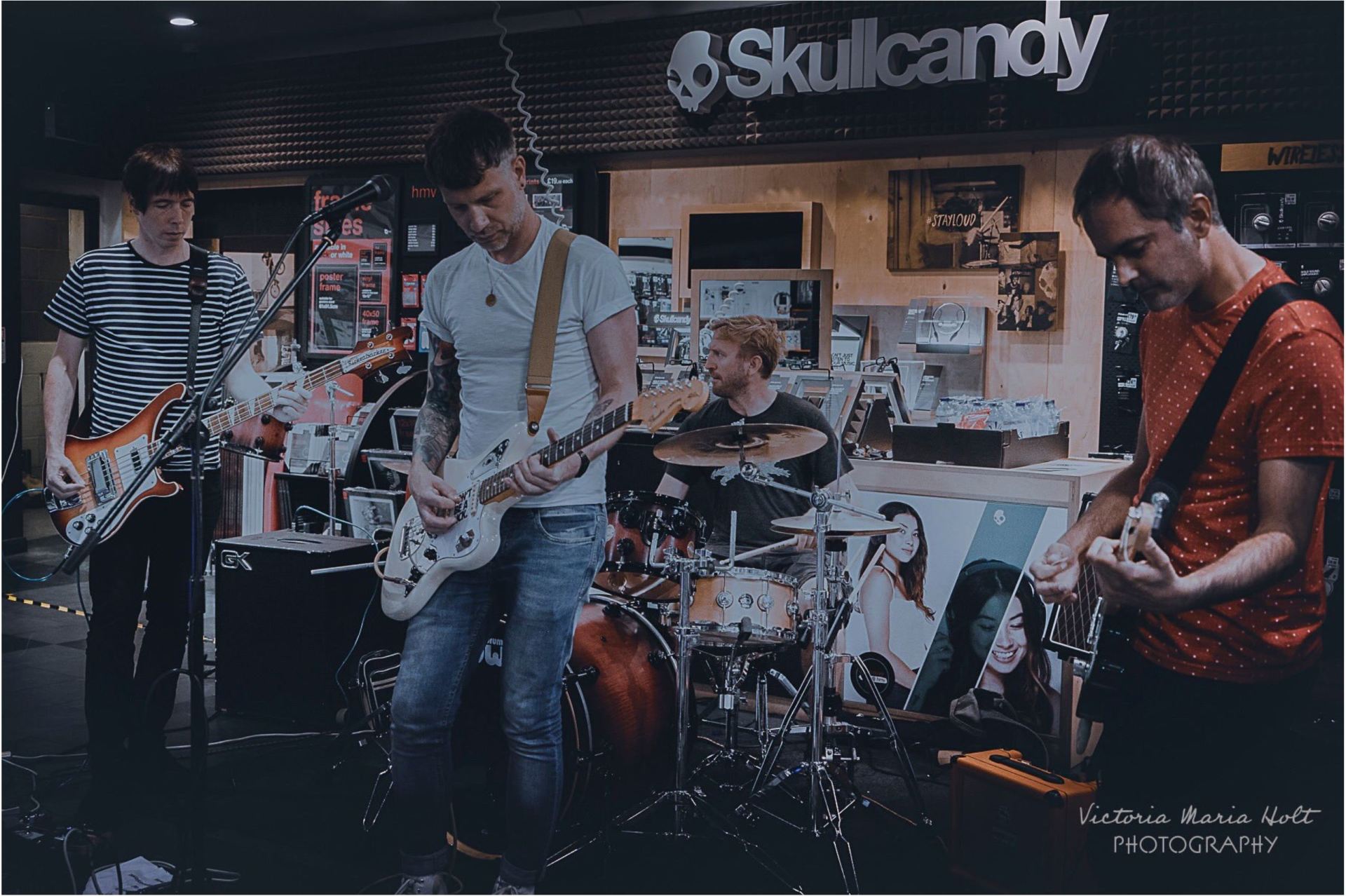A band is playing in front of a skullcandy store