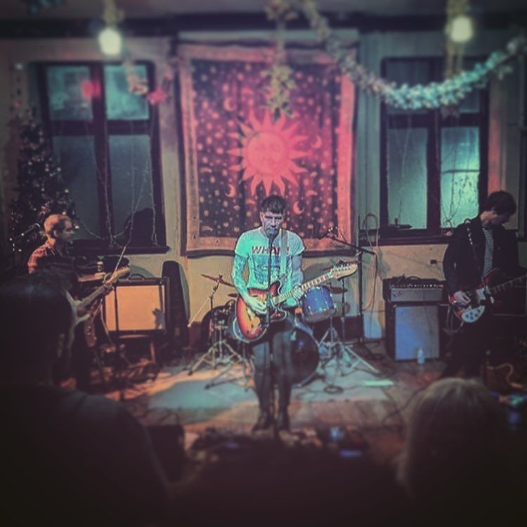 A man is playing a guitar on a stage in front of a crowd.