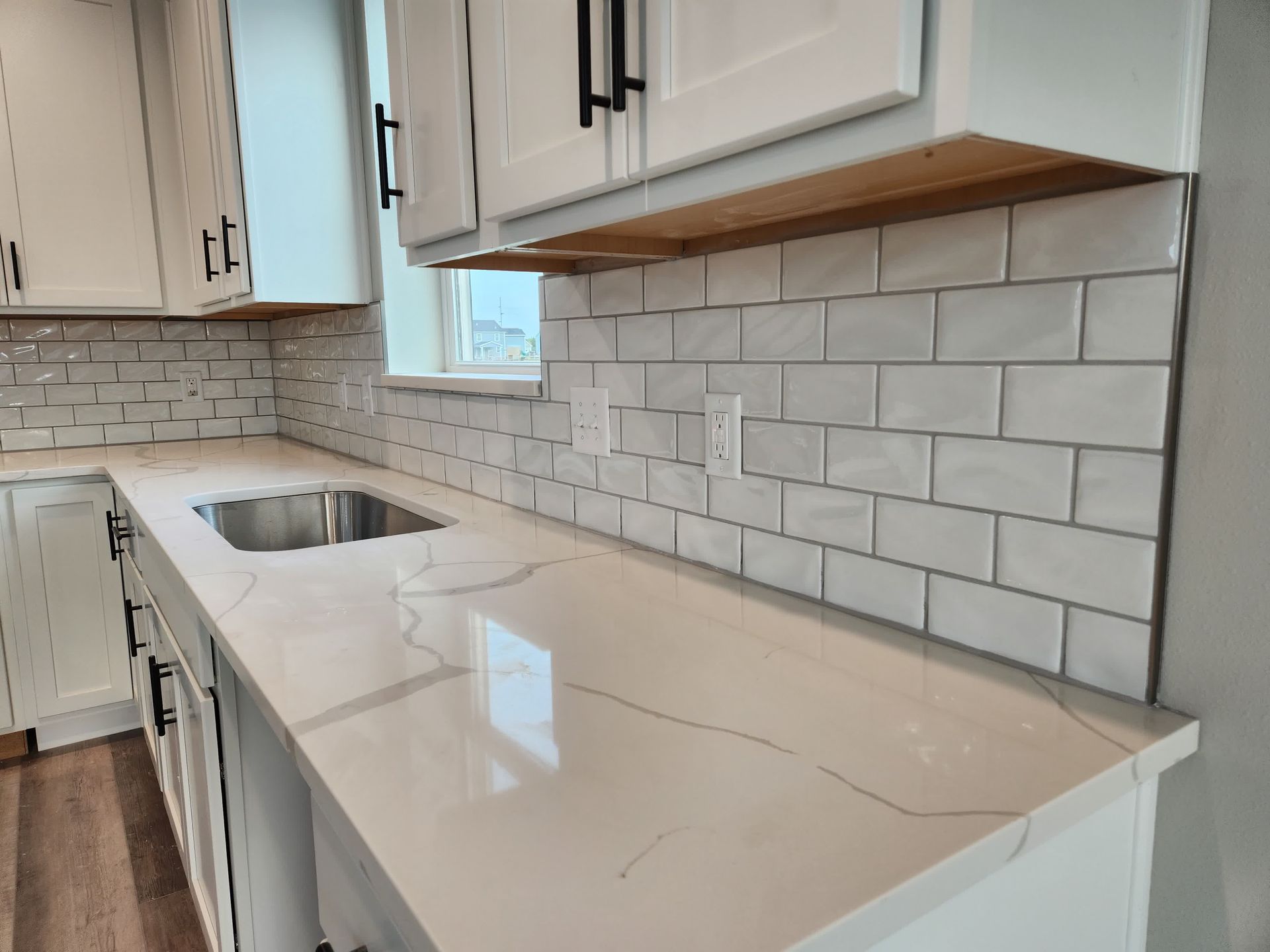 A man is applying tile adhesive to a tile floor.
