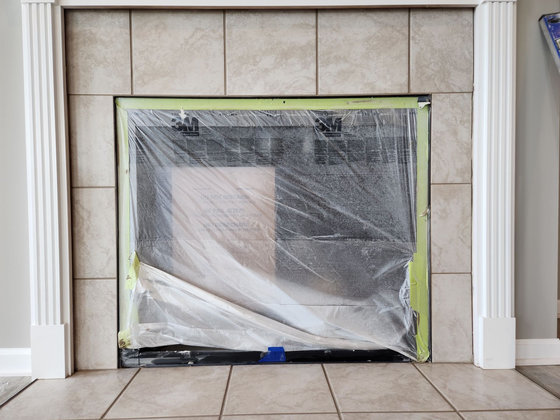 A person is laying tiles on a wall with a trowel.