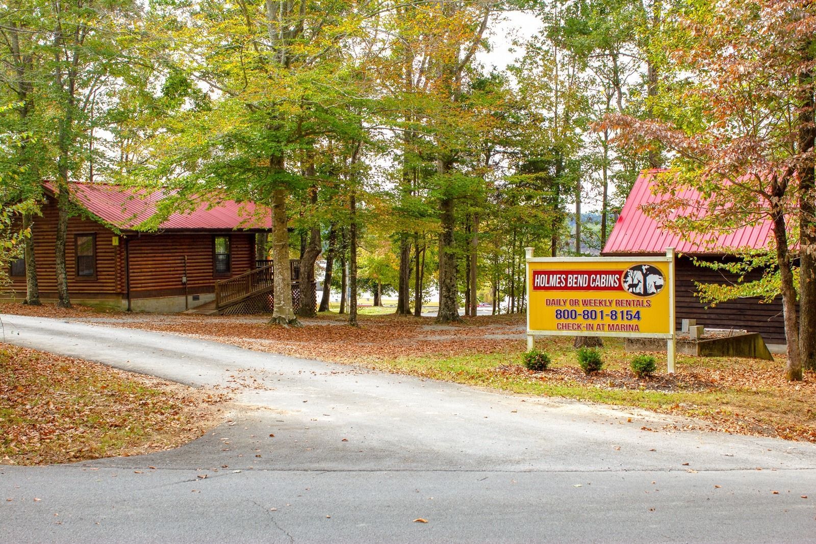 Log cabins with red roofs and a sign for