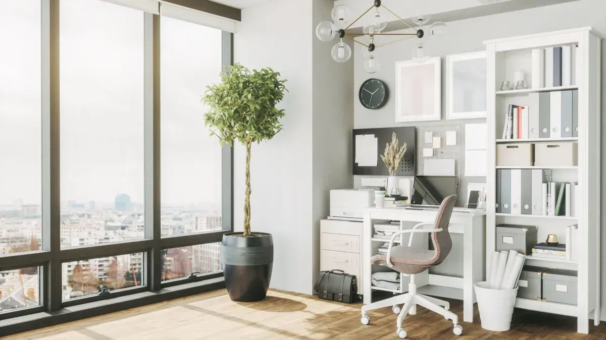 Modern home office with a built in desk, floating shelves, and natural lighting.