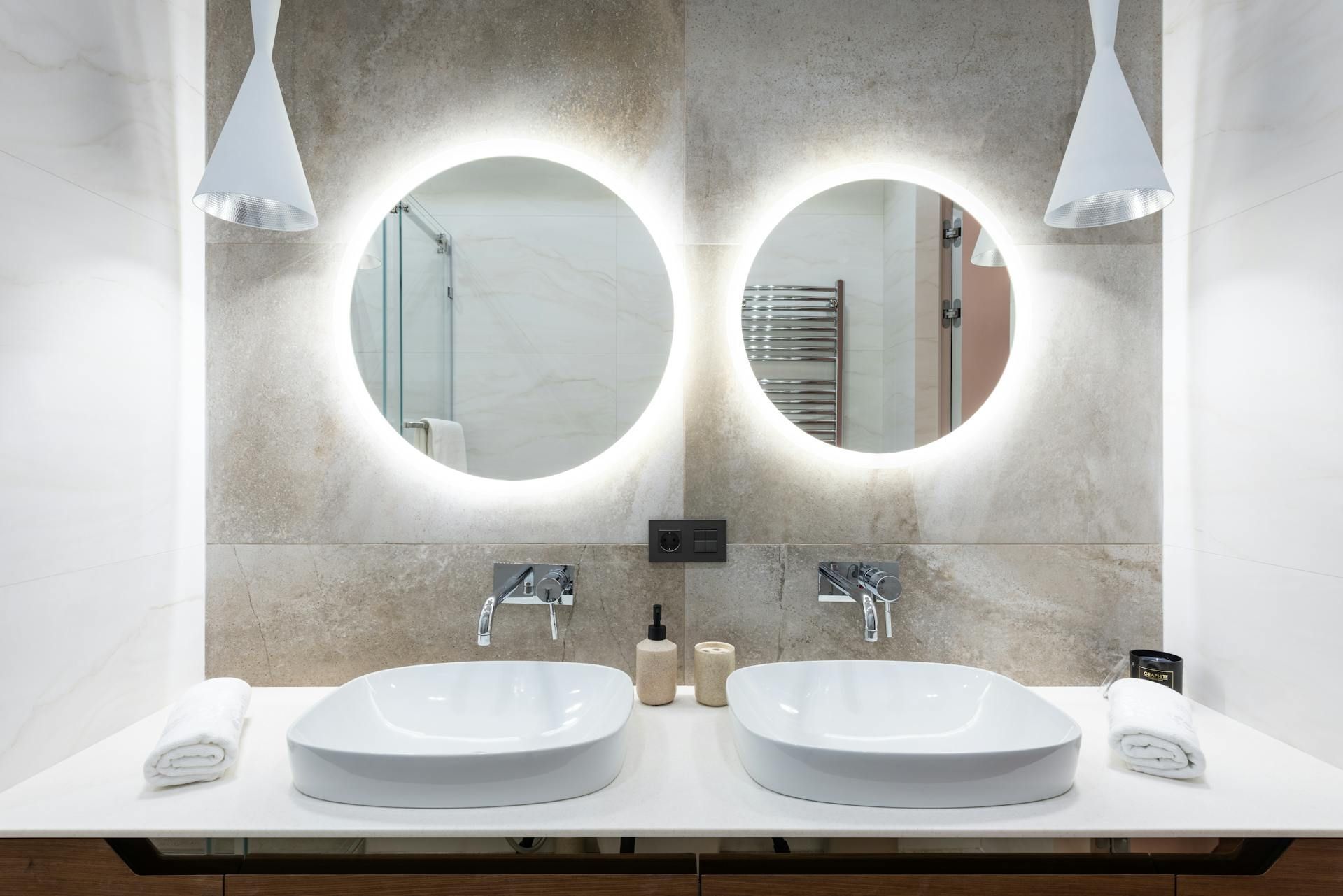 Modern dual vanity with sleek countertops, elegant mirrors, and stylish lighting.