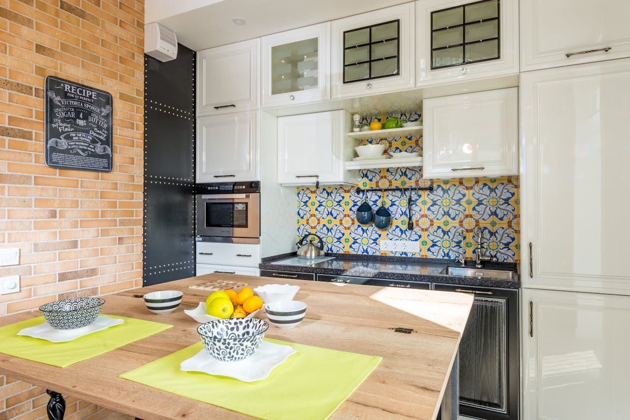 A kitchen with a table and a bowl of fruit on it.