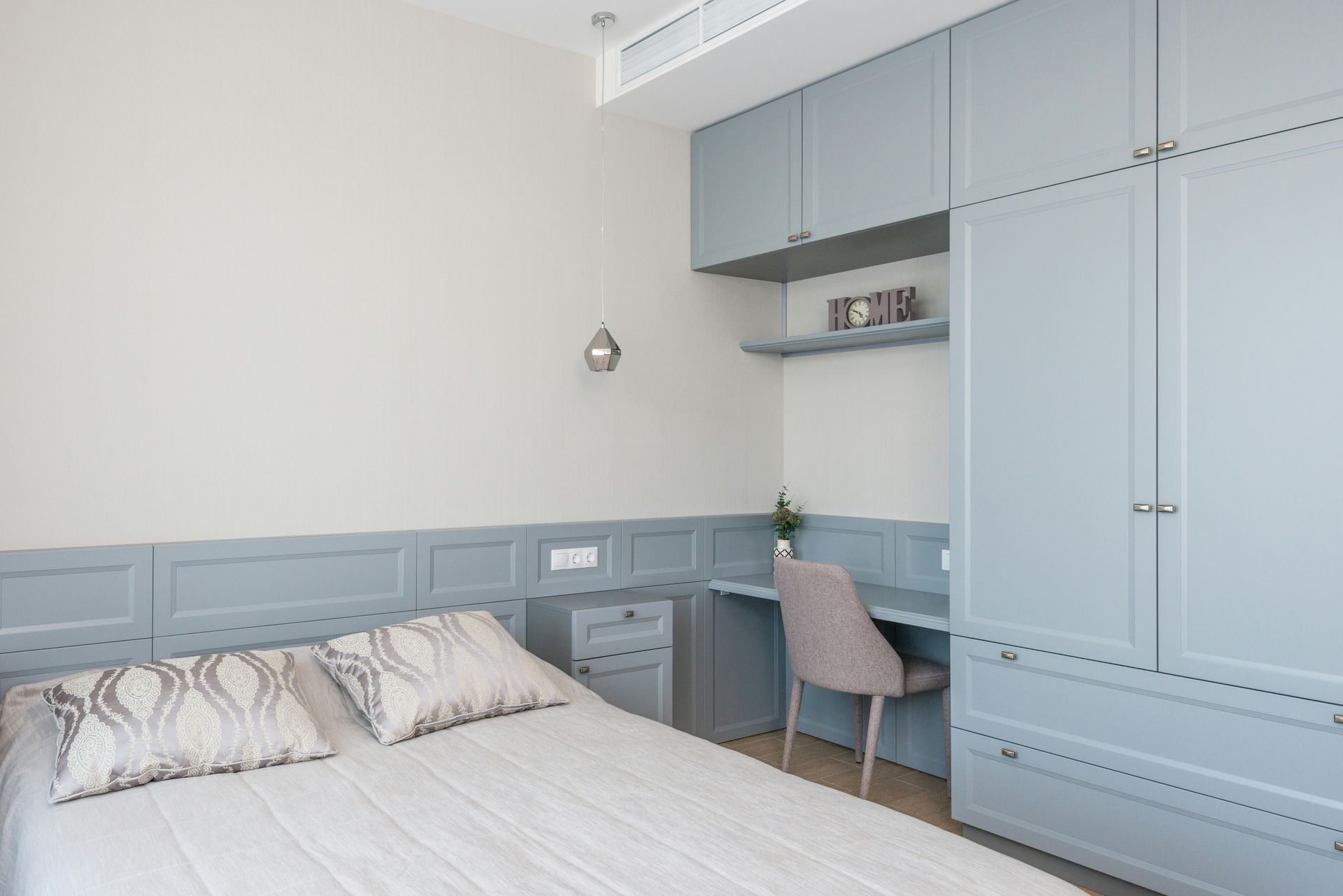 A bedroom with a bed , desk and closets.