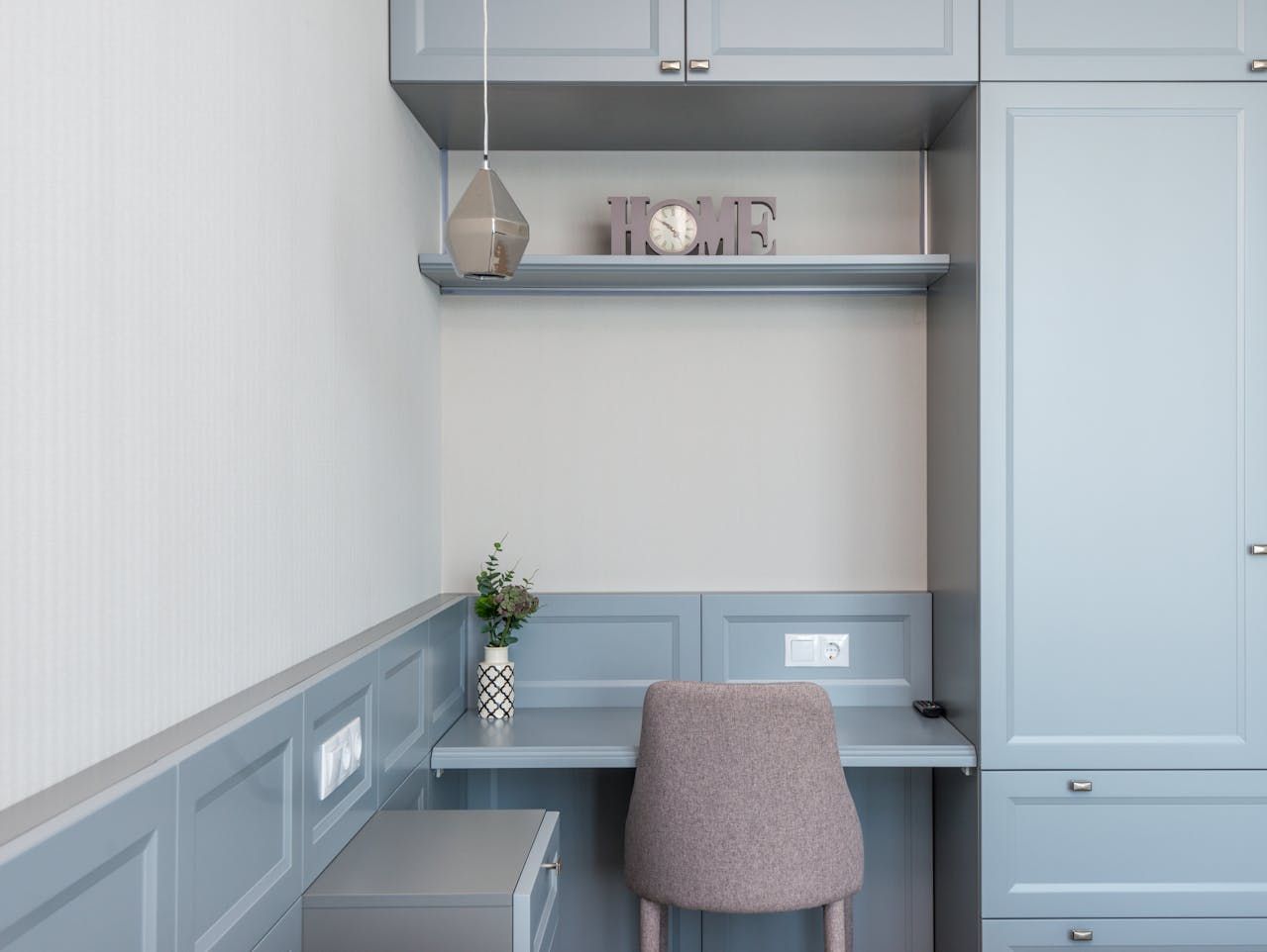 There is a desk with a chair in the corner of the room.