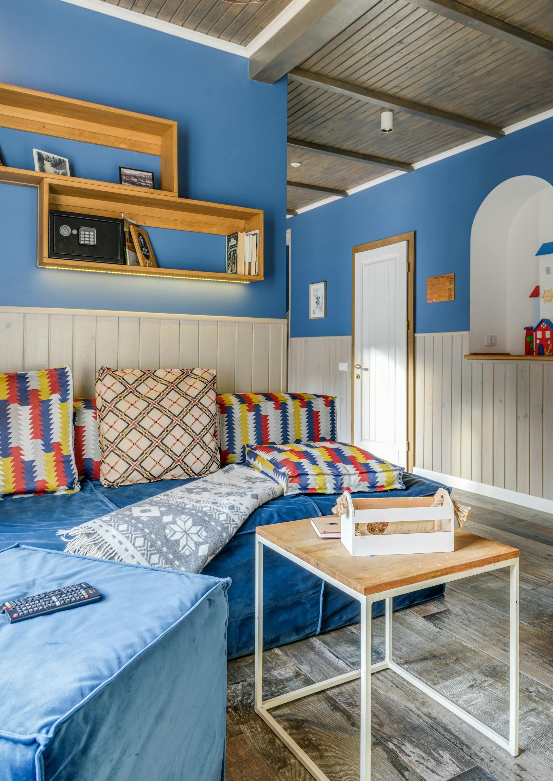 A living room with blue walls and a blue couch