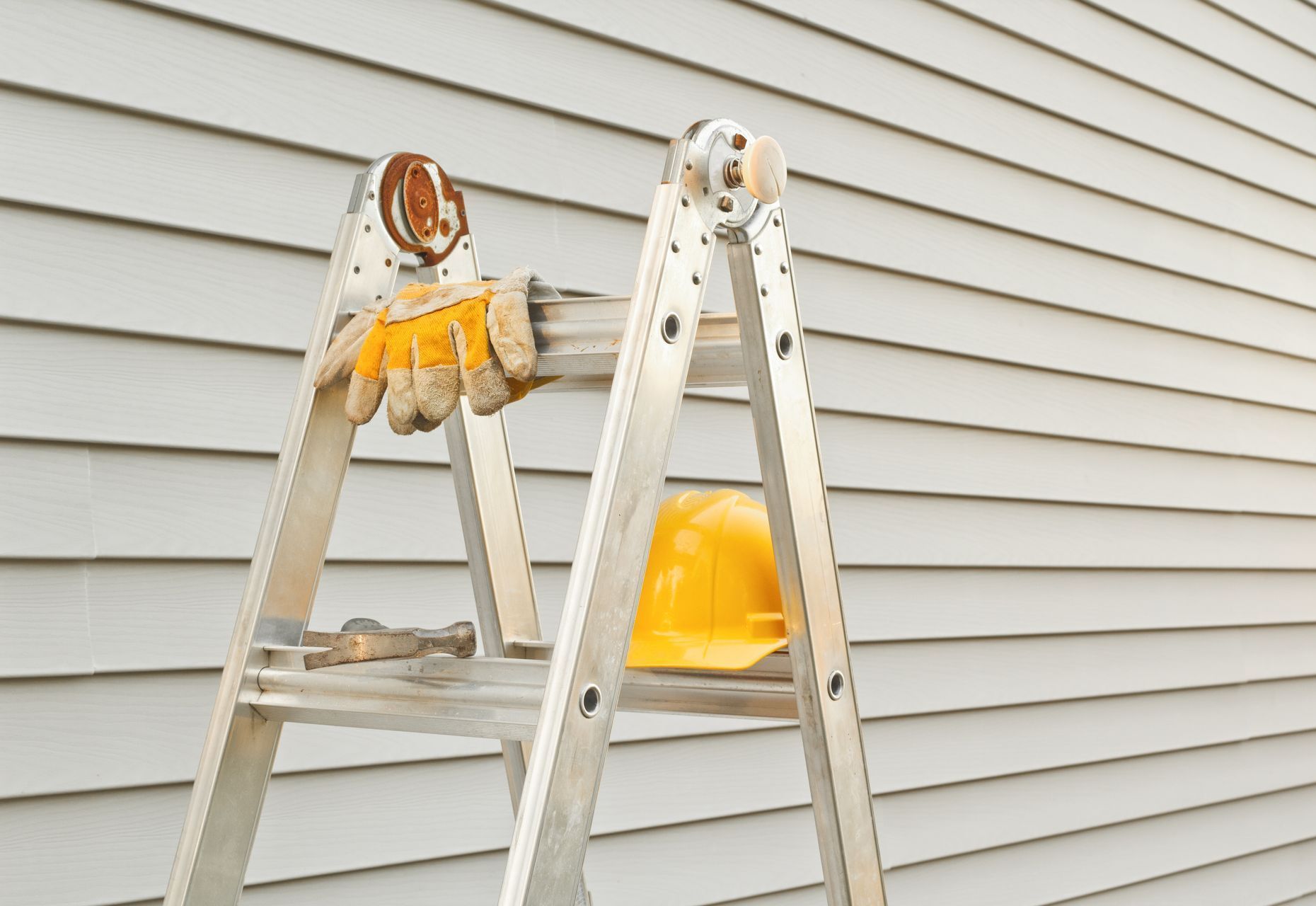 A ladder with a hard hat and gloves on it