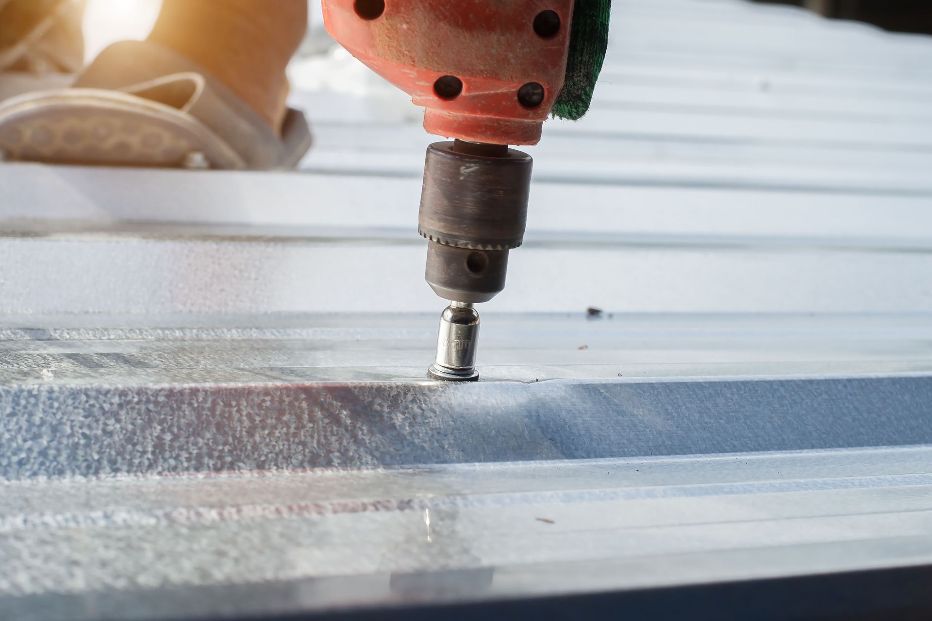 A person is using a drill to drill a hole in a piece of metal.