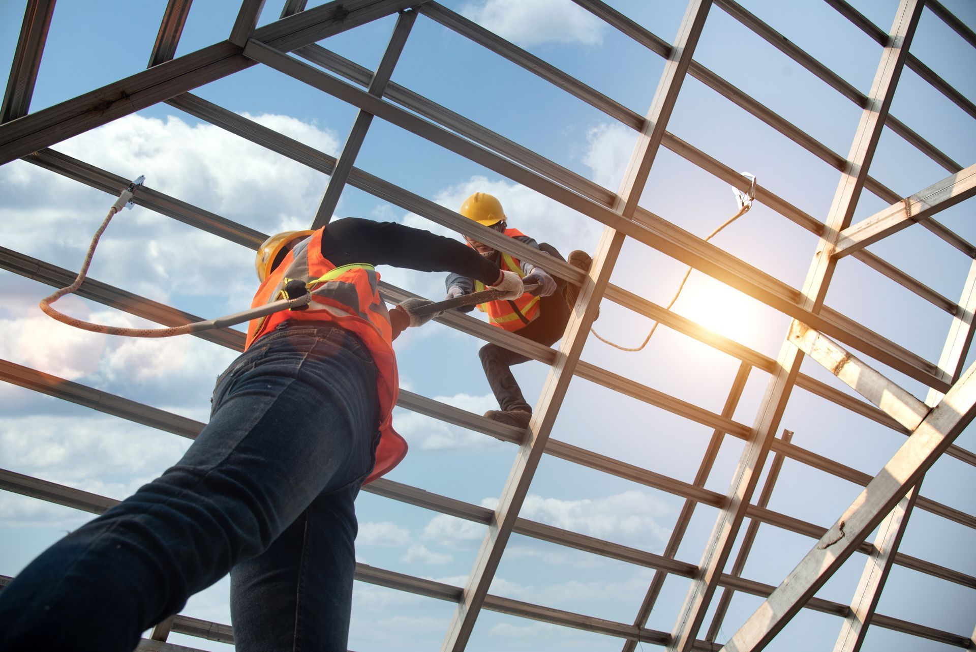 Two construction workers are working on the roof of a building.