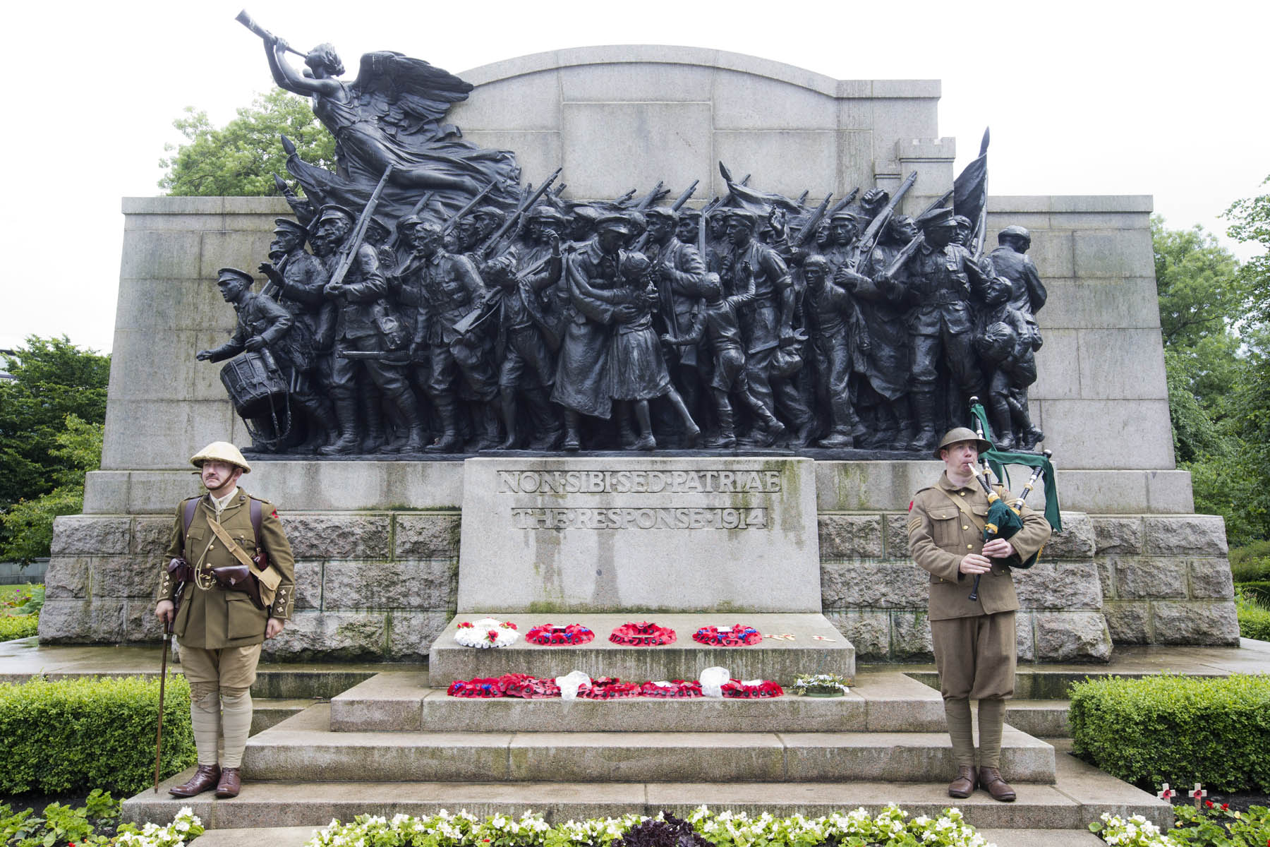 Two soldiers stand in front of a large statue