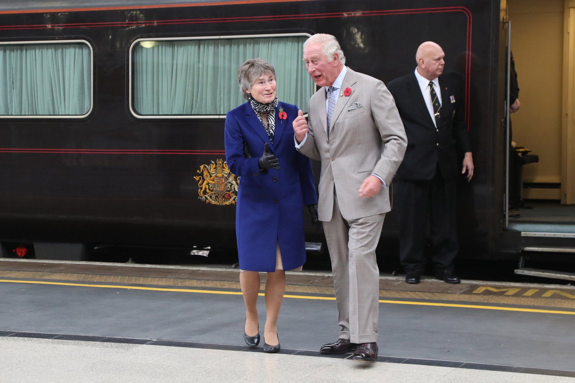 A man and a woman are walking in front of a train
