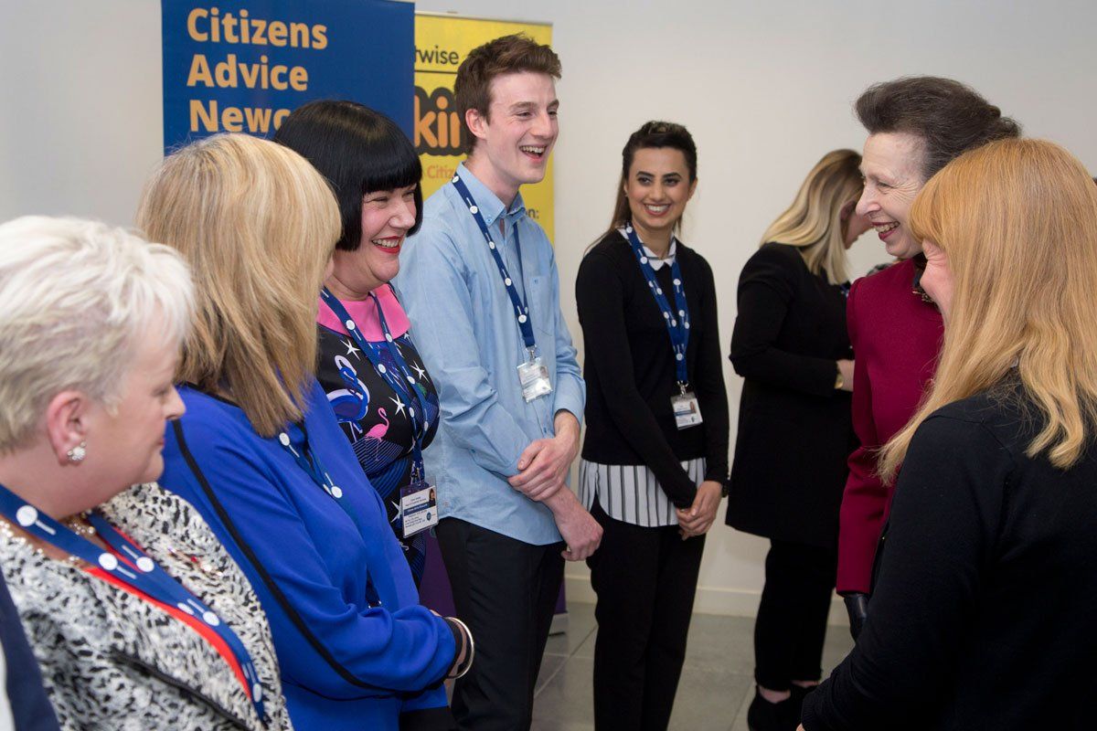 A group of people are standing in front of a sign that says citizens advice new