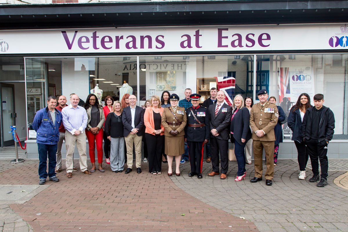 A group of people standing in front of a store called veterans at ease