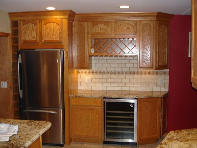 A kitchen with a large island in the middle and a dining room in the background.