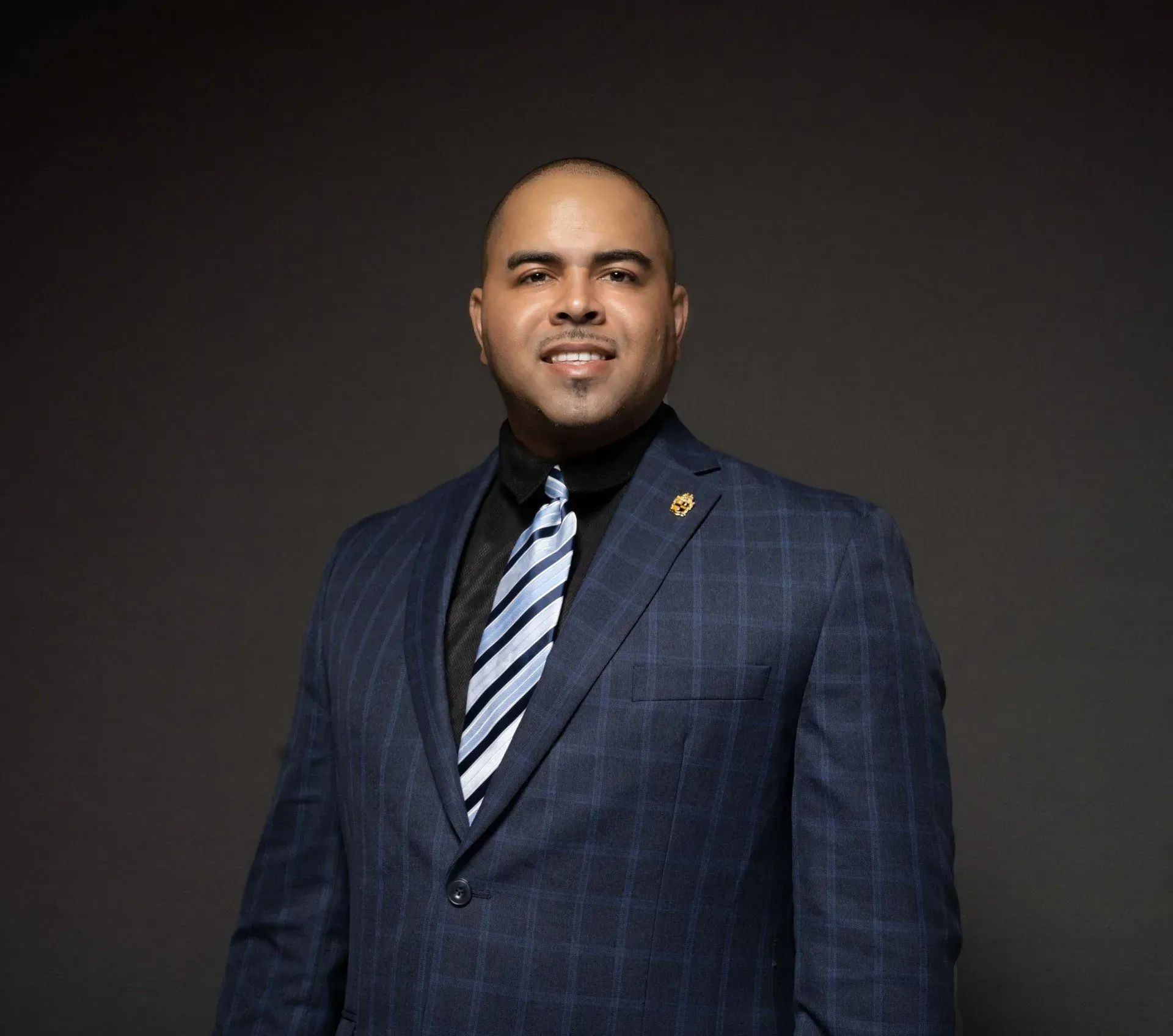 A man in a suit and tie is smiling for the camera