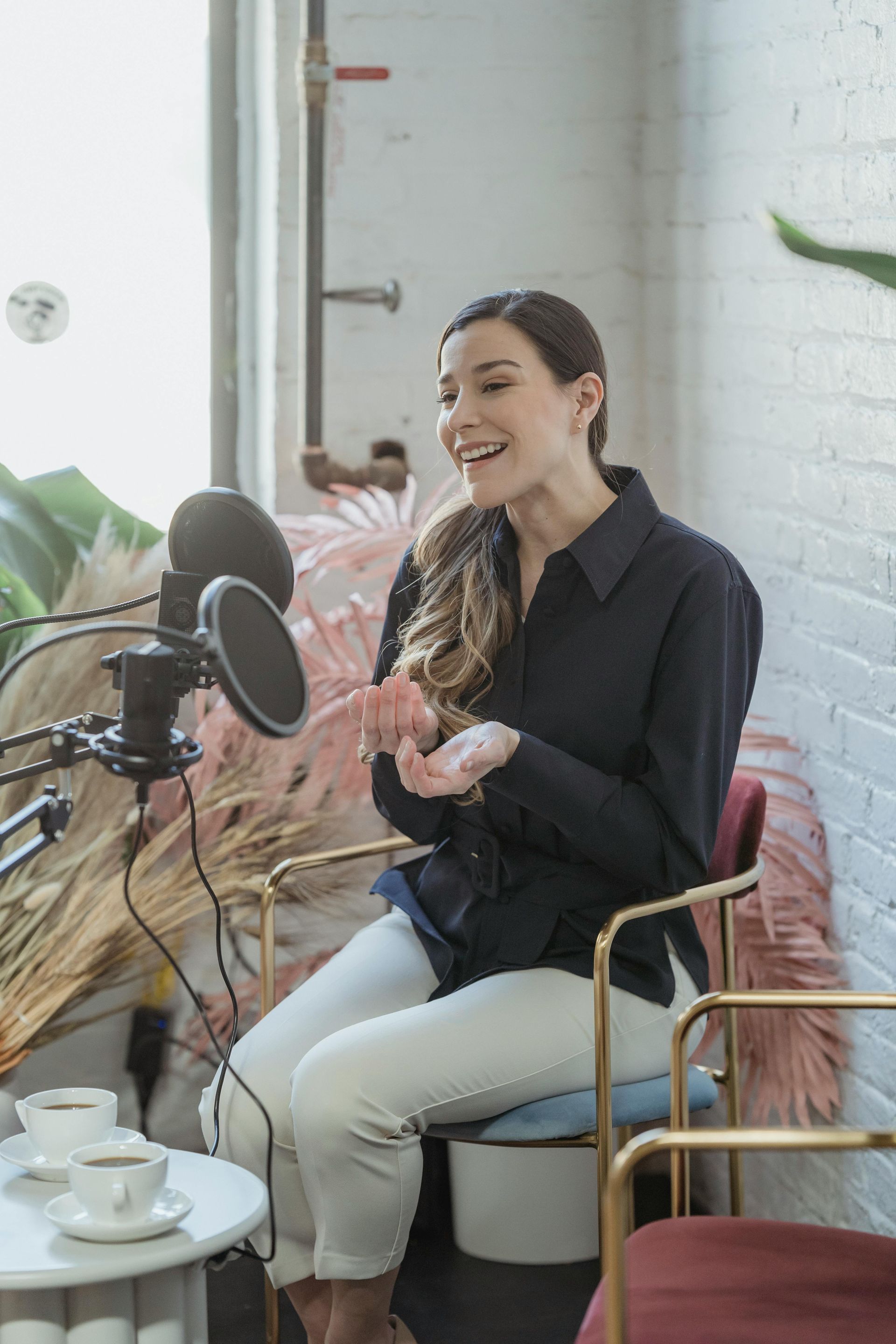 A woman is sitting in front of a microphone in a room.