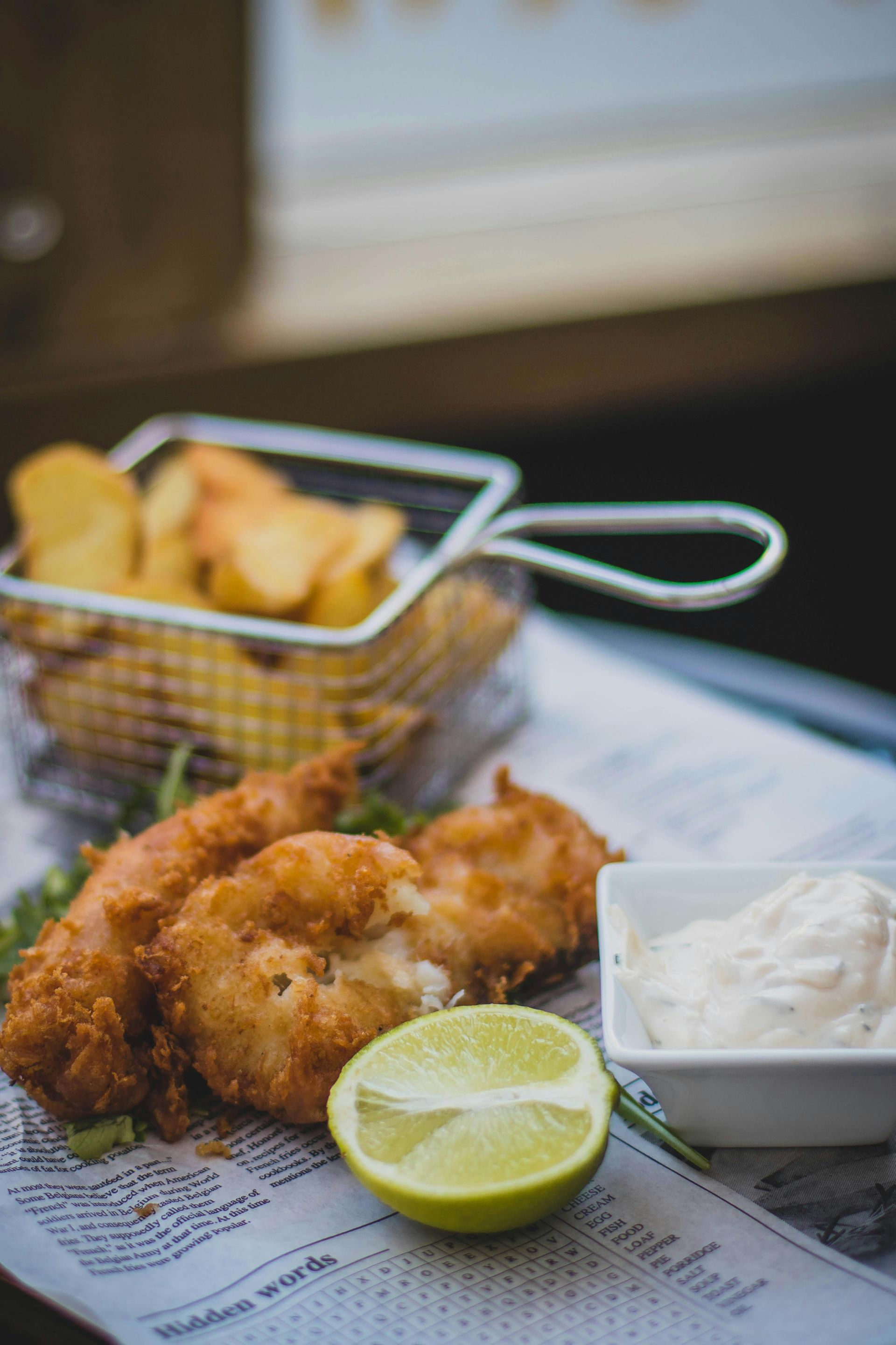Breaded schnitzel with fries, lemon wedge, ketchup, and lettuce on a white plate.