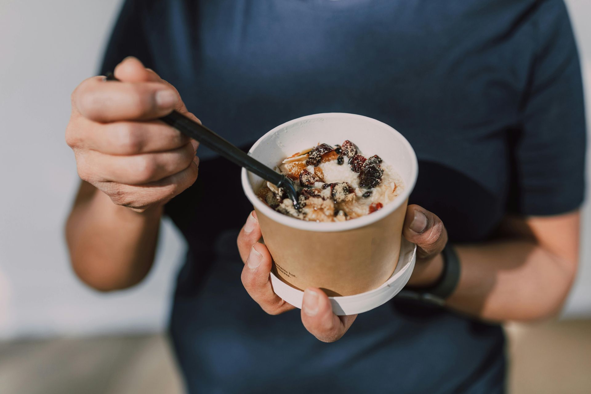 A bowl of Lucky Charms cereal with a golden spoon on a pink background.