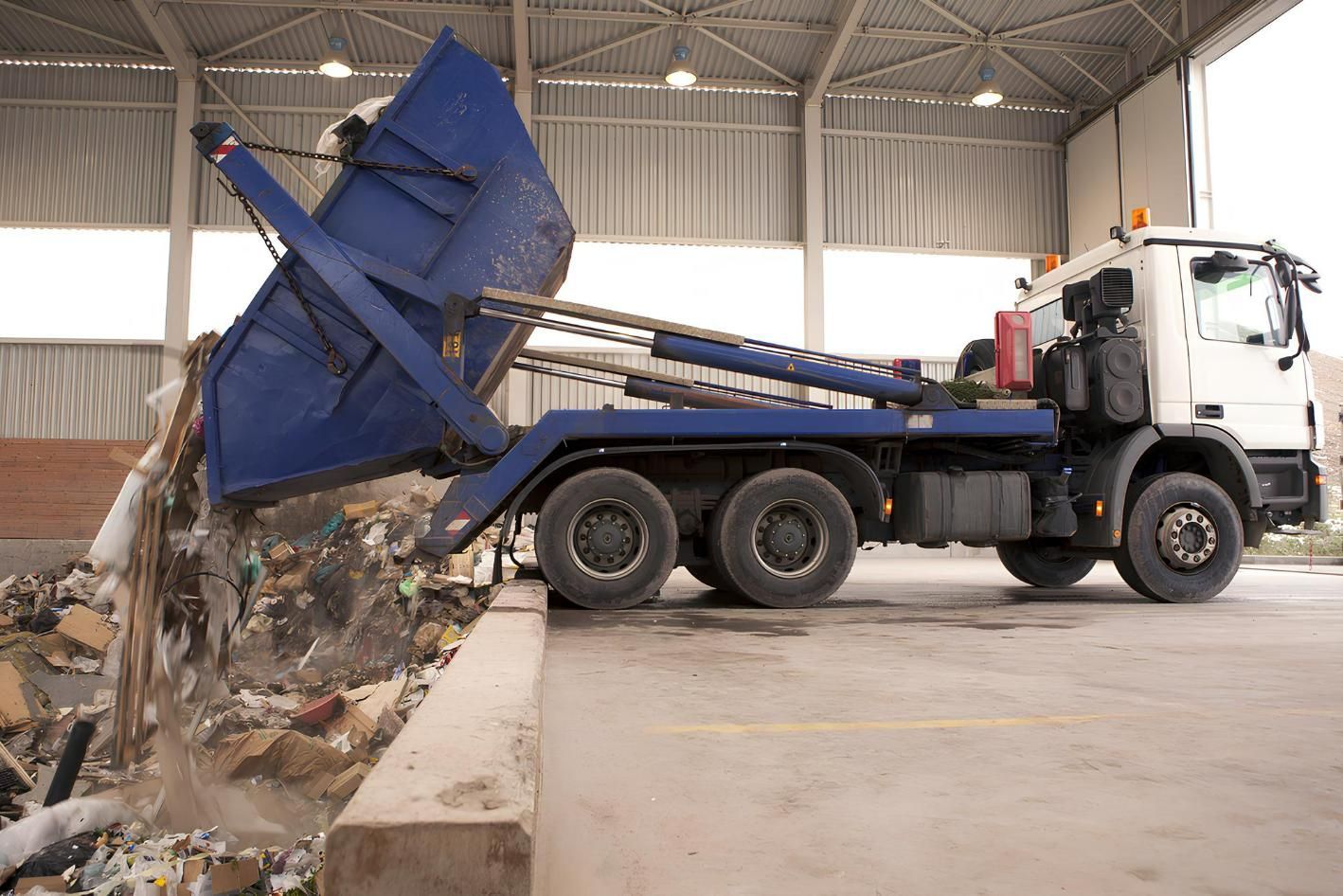 A Dump Truck is Dumping Trash Into a Pile of Trash — IBS Skip Bins in Wurtulla, QLD